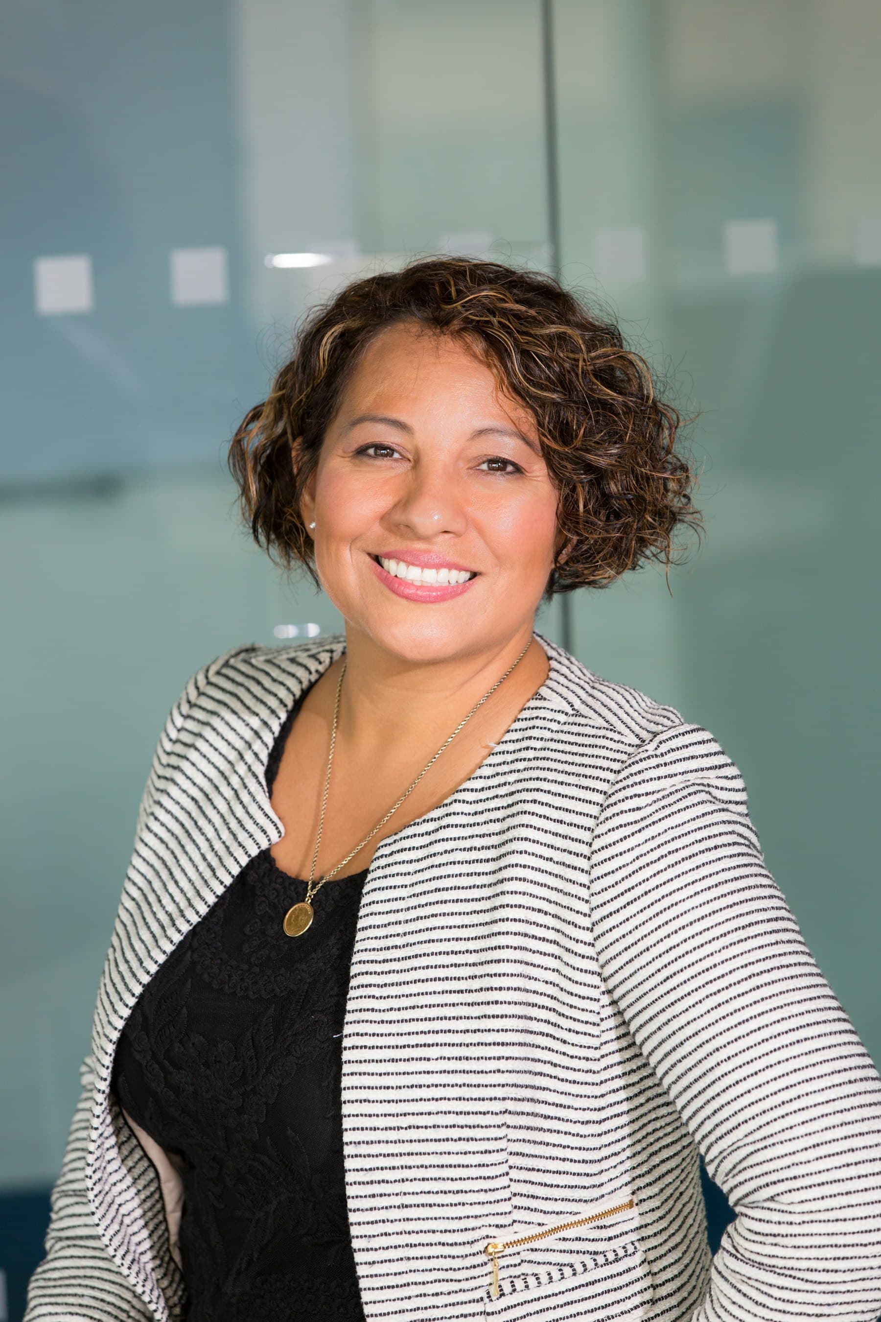Woman with curly hair smiling in an office
