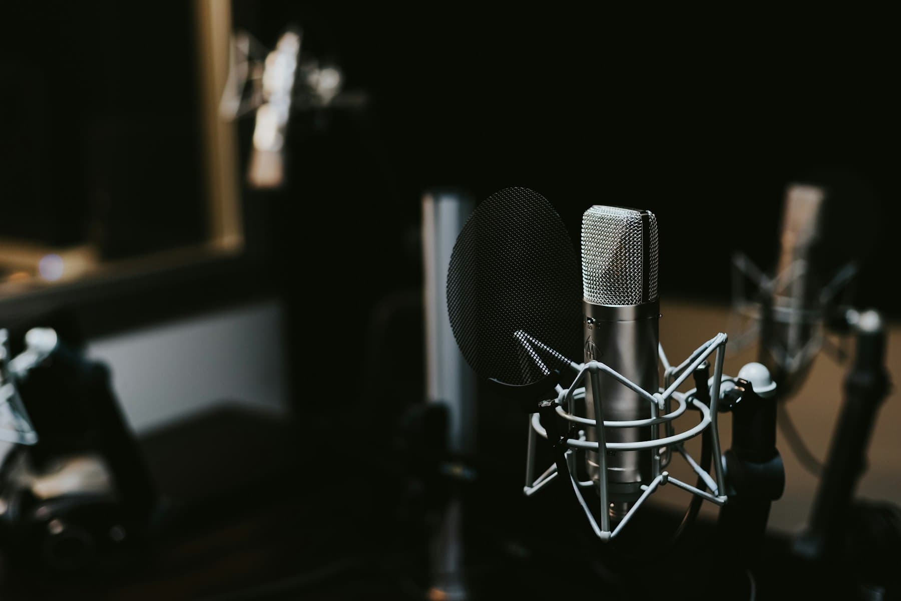 A condenser microphone in a dimly lit recording studio